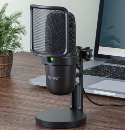 Desktop USB condenser microphone with pop filter on wooden desk near laptop