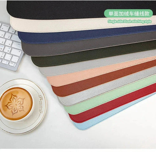Assorted desk mats in multiple colors on a desk beside a keyboard and latte art coffee.